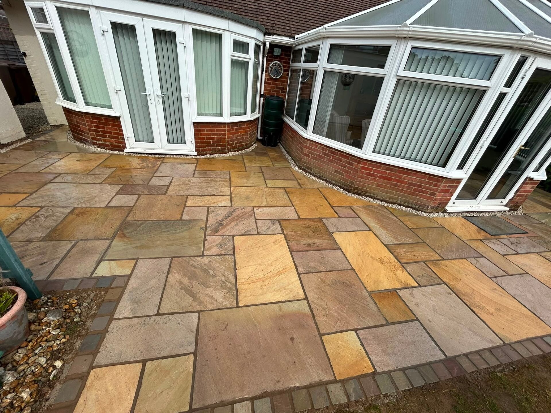 Indian sandstone patio installed around a conservatory at a Sussex property.