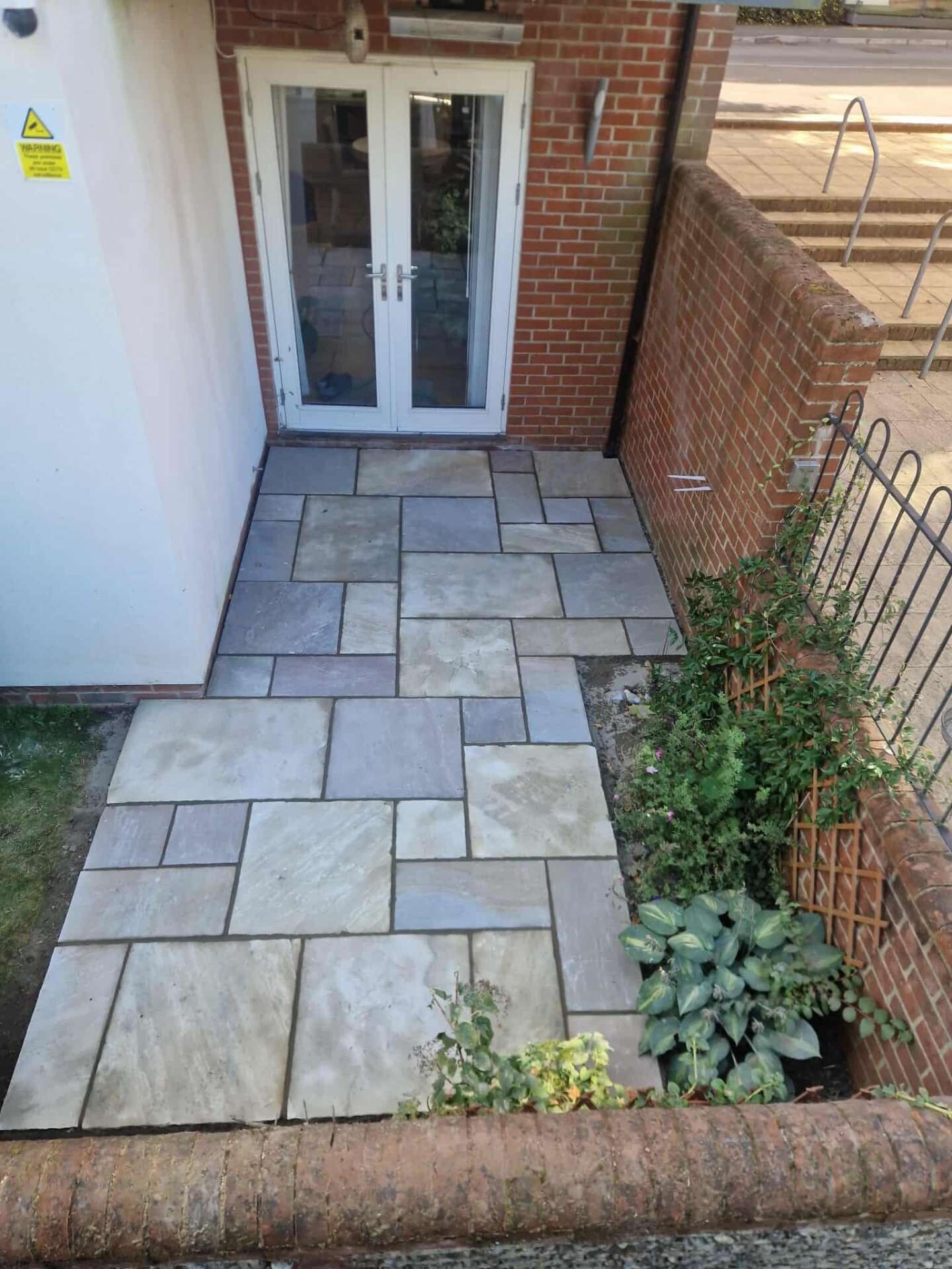 Hand-laid sandstone patio at the rear of a coastal Sussex bungalow.