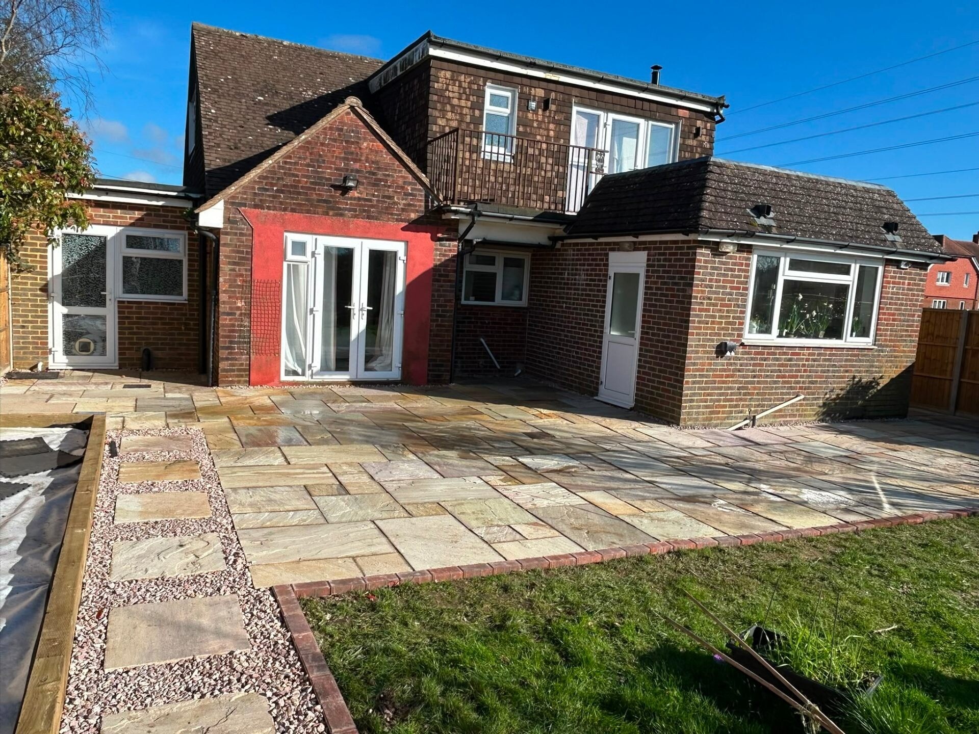 Sandstone patio laid edge-to-edge at a Sussex family home.