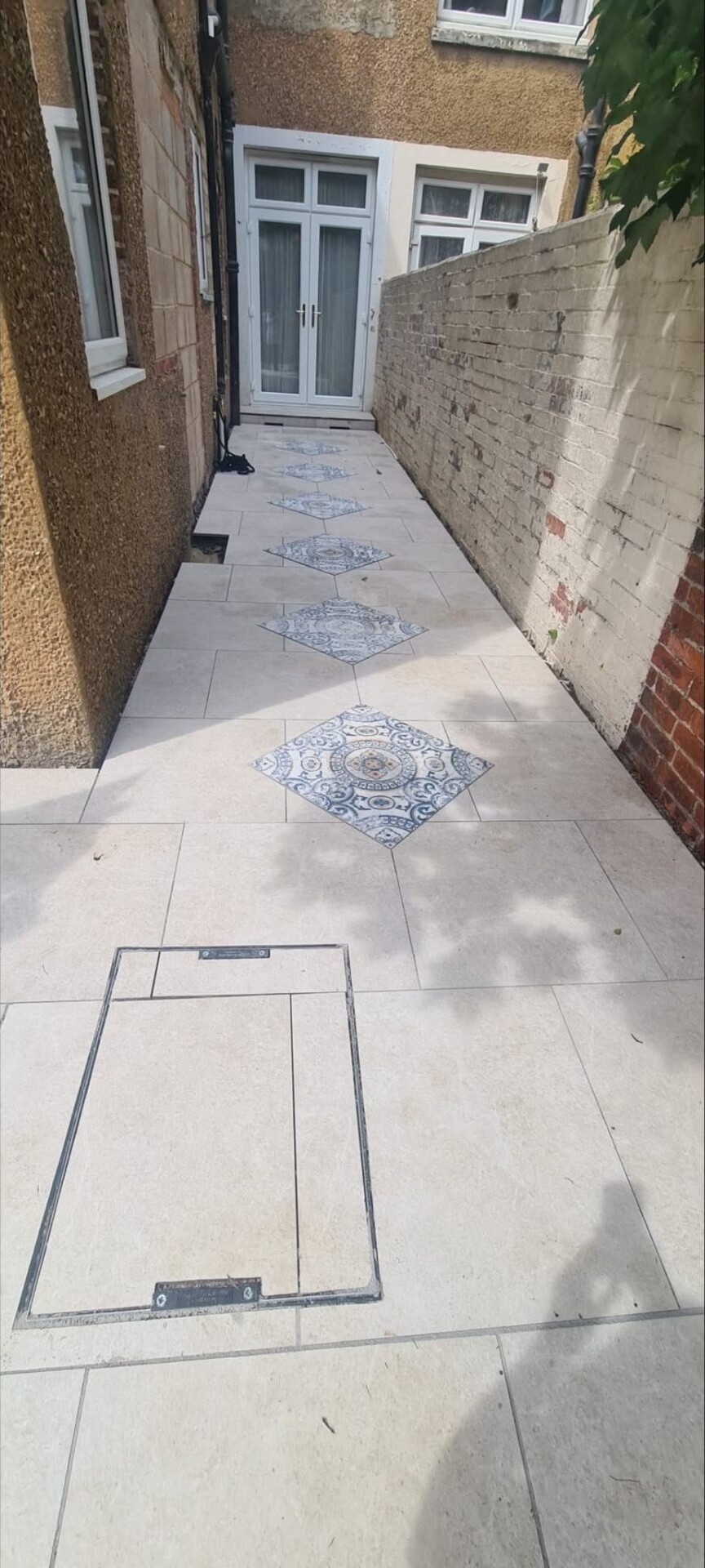 Cream porcelain path running along the side return of a Sussex home.
