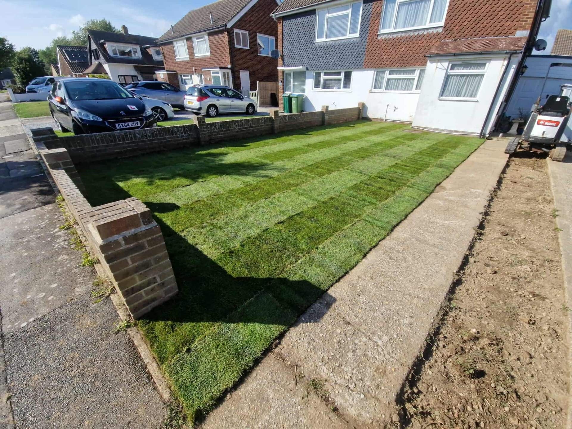 Freshly laid cultivated turf to a Sussex front lawn alongside new block paving.