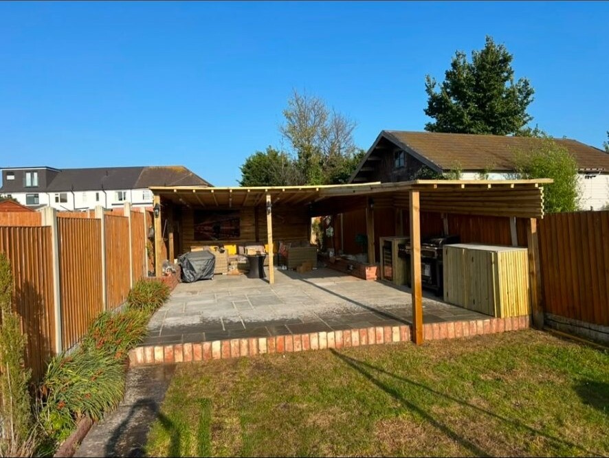 Covered outdoor entertaining area with timber-clad shelter and sandstone patio.